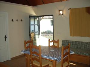 comedor con mesa, sillas y ventana en Camping La Aldea, en El Rocío