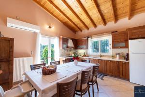 a kitchen with a table with chairs and a white refrigerator at Villa Pine Forest in Corfu Town