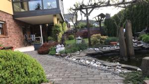 einen Garten mit einem Teich und einem Haus in der Unterkunft Ferienwohnung Le in Adenau