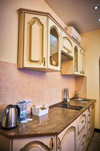 a kitchen with white cabinets and a counter top at Hotel Leo in Lviv