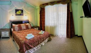 a bedroom with a bed and a large window at Hotel Leo in Lviv