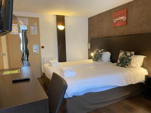 een hotelkamer met een bed en een bureau bij SHELDER Hôtel - CHERBOURG EN COTENTIN - Equeurdreville in Cherbourg en Cotentin