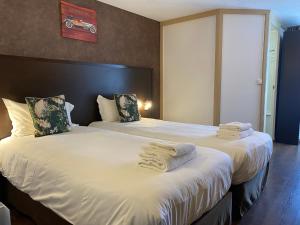 twee bedden in een hotelkamer met handdoeken erop bij SHELDER Hôtel - CHERBOURG EN COTENTIN - Equeurdreville in Cherbourg en Cotentin