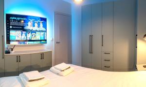 ein Schlafzimmer mit einem Bett und einem TV an der Wand in der Unterkunft Made for You AMC apartament przy AquaParku in Rumia