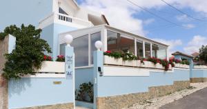 une maison bleue et blanche avec des fleurs sur le balcon dans l'établissement Villa da Praia, à Sintra