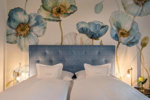 een slaapkamer met een bed met blauwe bloemen aan de muur bij Boutique Hotel Relais Chalet Wilhelmy in Bad Wiessee