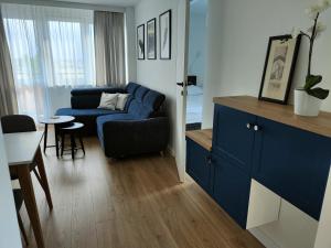 uma sala de estar com um sofá azul e uma mesa em Perełka (by F&J) em Toruń