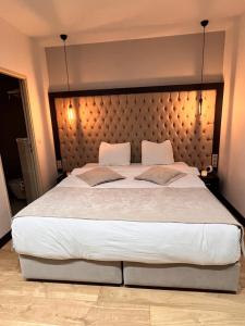 - une chambre avec un grand lit et une grande tête de lit dans l'établissement Paris Luxury Guest House - CDG Aéroport, à Roissy-en-France