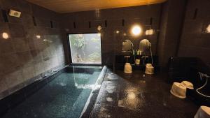 a bathroom with a swimming pool with a window at Hotel Route-Inn Ichinoseki Inter in Ichinoseki