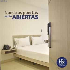 1 cama con almohadas blancas en una habitación en Hotel Blu Cúcuta, en Cúcuta