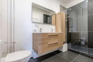 La salle de bains est pourvue de toilettes, d'un lavabo et d'une douche. dans l'établissement Plumeria - Grand Appartement 75m2 - Au calme - Proche Gare, Nouvelle Ville - Parking Public Gratuit - 2 Chambres - 4 Lits séparés, à Metz