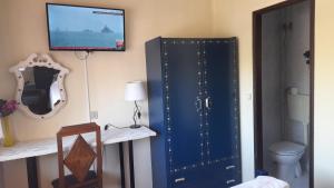 Zimmer mit einem blauen Schrank und einem TV an der Wand in der Unterkunft Residencia Maria Jose in Fátima