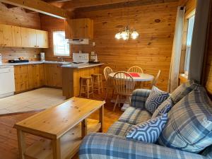 sala de estar con sofá y mesa en Avonlea Forest Hill Cottages, en New Glasgow