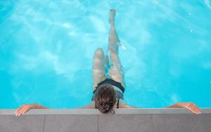 una mujer flotando en una piscina en Nicey - Hôtel Spa, Lounge, Coworking, en Romilly-sur-Seine