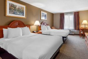 RockportにあるQuality Inn & Suites Rockport - Owensboro Northのベッド2台とデスクが備わるホテルルームです。