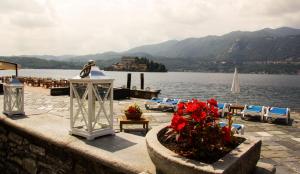 vista su un lago con sedie e statua di Hotel San Rocco a Orta San Giulio