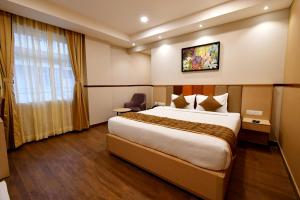 een hotelkamer met een groot bed en een raam bij Soho Boutique Hotel in Mysore