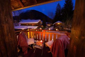 um alpendre de um chalé com uma mesa e cadeiras em Hotel Mas de la Coutettaz, The Farmhouse em Morzine