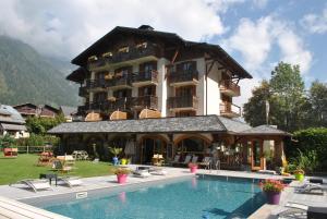 um grande edifício com uma piscina em frente em Oustalet em Chamonix-Mont-Blanc