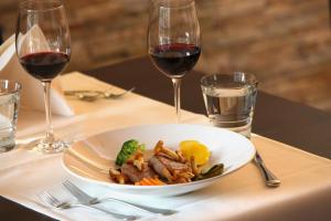 un plato de comida en una mesa con dos copas de vino en Hotel Ochsen, en Menzingen