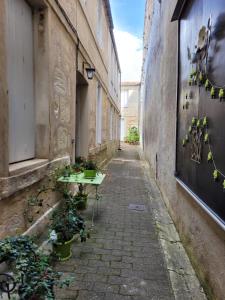 Une allée avec une table et des plantes en pot dans l'établissement Le Studio 64, à Rochefort