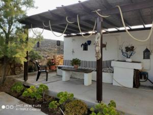 uma pérgola com um banco num pátio em Villa Ateni em Gavrio