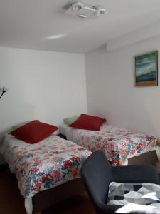 um quarto com duas camas e uma cadeira. em Studio La Rotonde em Waterloo