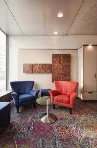 a waiting room with two chairs and a table at Stadthotel am Wasen in Stuttgart