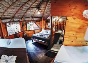 a bedroom with two beds in a thatched room at Raiz Kite Cabana in Jericoacoara