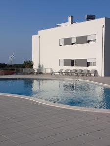 een zwembad voor een gebouw bij Sonho do Mar Ap. in Nazaré