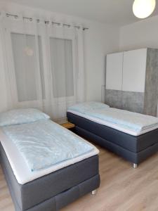 2 aparte bedden in een slaapkamer met een spiegel bij Eisenstadt Apartments in Eisenstadt