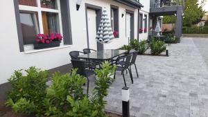 a patio with a table and chairs and flowers at Holdudvar Apartman in Gyula