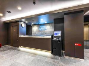 un bancomat nella hall con un cartello di HOTEL LiVEMAX Okazaki a Okazaki