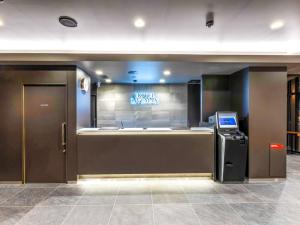 una hall con un cartello che indica l'hotelleighagency di HOTEL LiVEMAX Okazaki a Okazaki