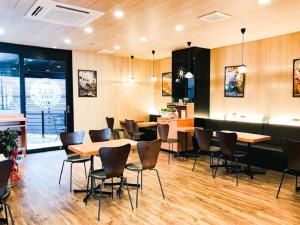 un ristorante con pavimenti e tavoli in legno e sedie di HOTEL LiVEMAX Okazaki a Okazaki