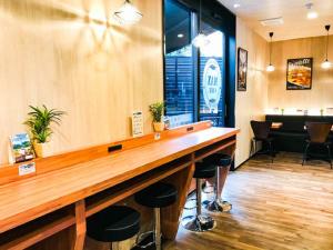 un bar in un ristorante con bancone e sgabelli di HOTEL LiVEMAX Okazaki a Okazaki