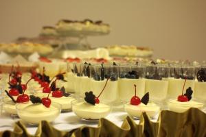 a table with desserts in bowls with cherries on them at Hotel Stary Młyn in Suchedniów