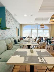 een restaurant met tafels en banken in een kamer bij Soho Boutique Puerto in El Puerto de Santa María