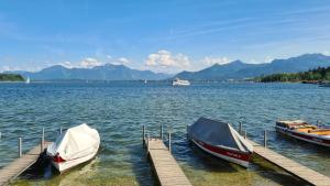 Hotel Schlossblick Chiemsee في برين أم كيمزيه: يتم رسو مركبين في مرسى على البحيرة