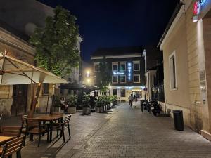 an empty street at night with tables and chairs at Fullton Central in Cluj-Napoca