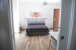 Schlafzimmer mit einem Bett und Holzboden in der Unterkunft Le Suite del Pastore in Lecce