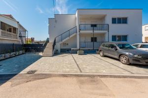 un'auto parcheggiata in un parcheggio di fronte a un edificio di Apartmani Diva a Zara (Zadar)