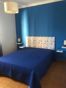 ein blaues Schlafzimmer mit einem Bett mit blauer Wand in der Unterkunft Casa dos Pais in Odeceixe