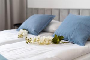 un letto con cuscini blu e fiori bianchi di Old Town Studio by Noclegi Renters a Breslavia