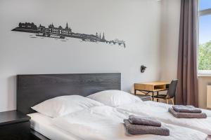 - une chambre avec un lit blanc et 2 serviettes dans l'établissement Hostel Am Windberg, à Freital