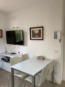 a dining room with a white table and chairs at Casa Lisa in Lenno