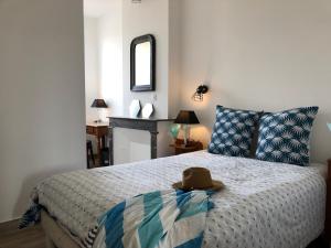 a bedroom with a bed with a hat on it at Le Logis de Virginie - climatisé in Rochefort