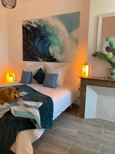 a bedroom with a bed and a painting on the wall at Le Logis de Virginie - climatisé in Rochefort