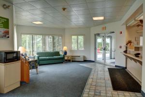 uma sala de espera com um sofá e uma televisão em Motel 6-Warwick, RI - Providence Airport - I-95 em Warwick