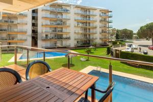 an apartment balcony with a table and a swimming pool at NIDO 150 Mestral in Roses